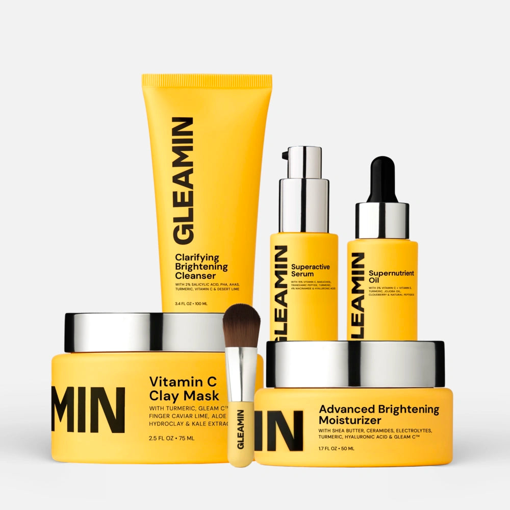 Brightening skincare set featuring GLEAMIN cleanser, clay mask, serum, oil, moisturizer, and applicator brush for radiant skin